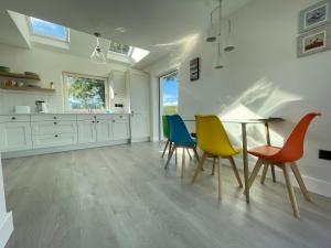 a kitchen with a table and colorful chairs at Kathleen's Carrowkeel Cottage in Sligo