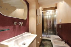 佛羅倫斯的住宿－烏菲茲哈莫尼旅館，一间带水槽、镜子和卫生间的浴室