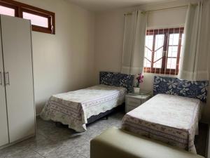 1 dormitorio con 2 camas y ventana en Apartamento Vera, en Florianópolis