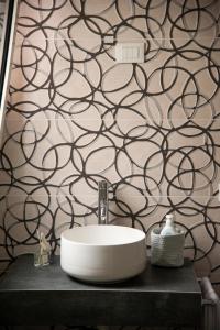 baño con lavabo y pared en blanco y negro en Casa Vittoria Guest House, en Romano D'Ezzelino