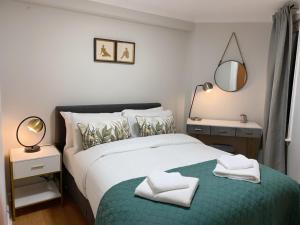 um quarto com uma cama com duas toalhas em Private Main Door Lovely 2 bedroom apartment em Edimburgo