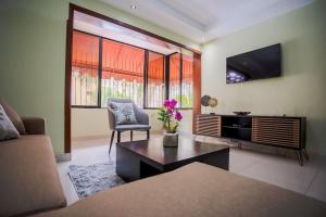 sala de estar con sofá y TV en Amplio apartamento en zona exclusiva con parqueo, en Los Prados