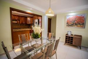 a dining room with a glass table and chairs at Amplio apartamento en zona exclusiva con parqueo in Los Prados
