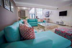 sala de estar con sofá azul y mesa en Impresionante villa con piscina Metro Country Club en Paraíso