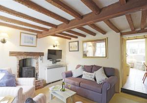 uma sala de estar com um sofá e uma lareira em Rose Cottage em Bealings