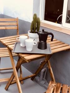 a wooden table with cups and a tea pot on it at Mar y Montaña Apartamento entero in La Costa