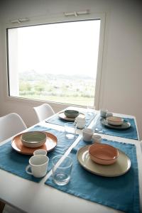 une table avec des assiettes et des verres sur un chiffon de table bleu dans l'établissement Casa Vittoria Guest House, à Romano D'Ezzelino