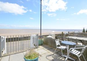 a patio with a table and chairs and the beach at Shoreline in Aldeburgh