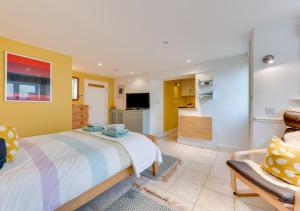 a bedroom with a large bed and a kitchen at Shoreline in Aldeburgh