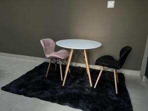 Pimville的住宿－Maponya Guest House，地毯上的白色桌子和两把椅子