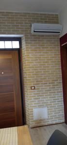 a room with a door and a brick wall at INTERNO 12 in Vercelli