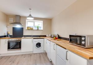 - une cuisine avec des appareils blancs et un comptoir en bois dans l'établissement Ardley Cottage Badger, à Waldingfield