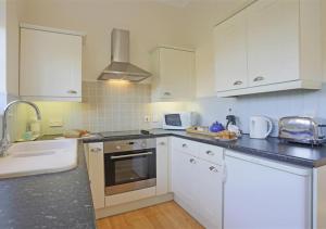 a kitchen with white cabinets and a sink at Garden View in Parham