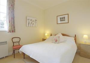 a bedroom with a white bed and a chair at Garden View in Parham