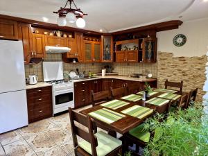 a kitchen with a table and a white refrigerator at Villa ZENKO in Lviv