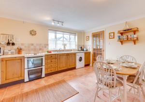 a kitchen with a table and a dining room at 1 Chequers Row in Friston