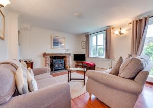 a living room with two couches and a fireplace at 1 Chequers Row in Friston