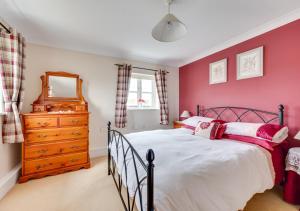 um quarto com uma cama, uma cómoda e um espelho em 1 Chequers Row em Friston