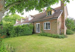 a brick house with a large yard in front of it at 1 Chequers Row in Friston