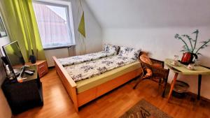 una camera da letto con un letto, un tavolo e una finestra di Burger Station - Zimmervermietung a Immendingen Altre 7 foto