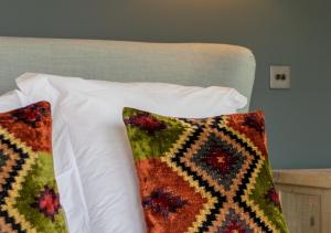 a bed with two pillows on top of it at The Old School House in Wickhambrook