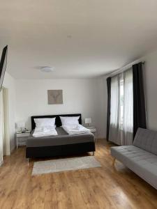 un dormitorio con una cama y un sofá en DEICHHÜTTE NORDDEICH, en Norddeich