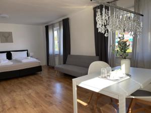 a living room with a bed and a chandelier at DEICHHÜTTE NORDDEICH in Norddeich
