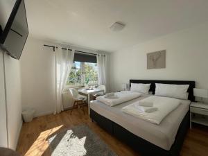 a bedroom with a bed with a desk and a window at DEICHHÜTTE NORDDEICH in Norddeich +12 photos