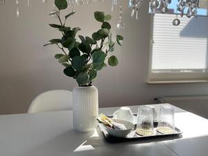 a white vase with a plant in it on a table at DEICHHÜTTE NORDDEICH in Norddeich