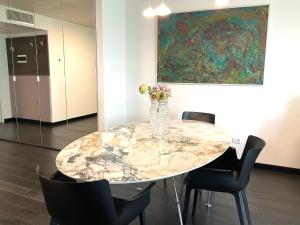 einen Esstisch mit einer Blumenvase darauf in der Unterkunft Grand Apartment Sissi in Triest