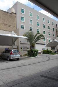 a car parked in a parking lot in front of a building at Hotel Portobelo in Guadalajara