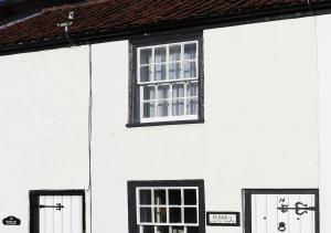a white house with black windows and doors at Pebbles Cottage in Southwold