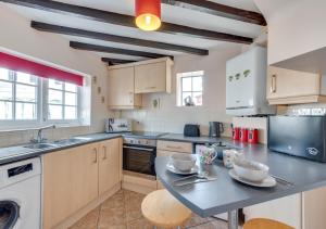 uma grande cozinha com uma mesa e cadeiras em Corner Cottage em Wangford