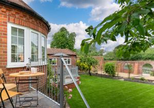 a garden with a patio and a lawn at Riverside Lodge in Beccles