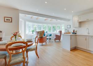 a kitchen and living room with a table and chairs at Riverside Lodge in Beccles