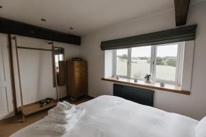 een slaapkamer met een wit bed en een raam bij BIRDS EDGE COTTAGE - Luxury 2 Bedroom Cottage with Amazing Views, Near Holmfirth in Yorkshire in Denby Dale