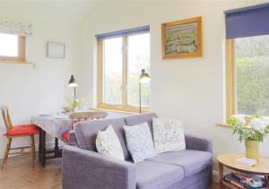 a living room with a couch and a table at Meadow Cabin in Henstead