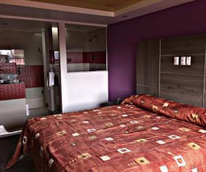 sypialnia z dużym łóżkiem i fioletowymi ścianami w obiekcie Hotel Rossel Plaza w mieście Meksyk
