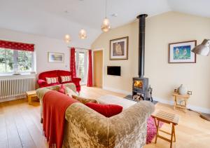 - un salon avec un canapé et une cheminée dans l'établissement Woodland Lodge, à Wilby