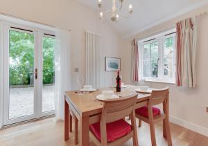 a dining room with a table and chairs and windows at Woodland Lodge in Wilby