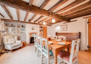 a dining room with a wooden table and chairs at Holly Cottage in Westleton