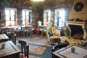 a restaurant with a fireplace and tables and chairs at Feggaropetra Inn Magic Mountain House in Palaios Panteleimonas