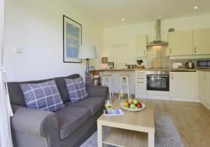 The Stables في Friston: غرفة معيشة مع أريكة وطاولة مع وعاء من الفاكهة