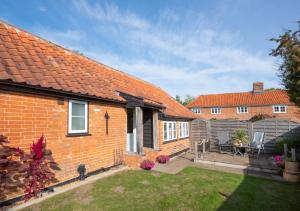 a brick house with a garden and a fence at Marlborough House Forge in Saxtead