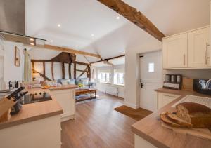a kitchen with white cabinets and a living room at Marlborough House Forge in Saxtead