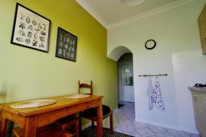 a dining room with a table and a clock on the wall at Apartament Dana in Kołobrzeg
