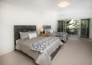 a bedroom with two beds and a balcony at Modern Beaver Creek Private House! in Avon