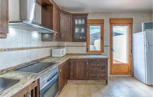 una cucina con armadi in legno e frigorifero bianco di Cozy Home In Torres With Kitchenette a Torres