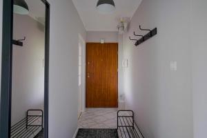 a hallway with a wooden door and a mirror at Apartament Dana in Kołobrzeg +3 photos