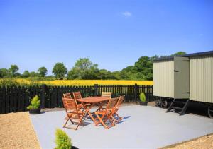 a patio with a table and chairs and a fence at Barn Owl Retreat Sibton in Sibton